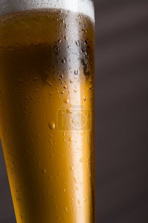 Foto de Detalle de un vaso de cerveza fría pálida sobre una mesa rústica de madera. Enfoque selectivo - Imagen libre de derechos