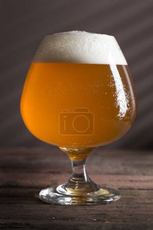 Téléchargez les photos : Verre de bière froide non filtrée sur une table en bois rustique - en image libre de droit