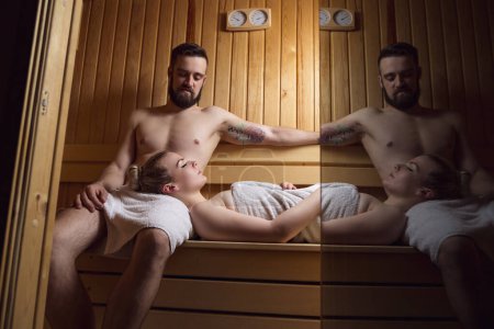 Téléchargez les photos : Jeune couple profitant de la séance de sauna ensemble et relaxant - en image libre de droit