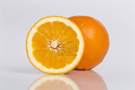 Téléchargez les photos : Gros plan d'un tout et d'une coupe transversale d'un fruit orange isolé sur un fond blanc. Focus image empilée - en image libre de droit