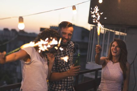 Téléchargez les photos : Groupe de jeunes amis s'amuser à une fête sur le toit - en image libre de droit