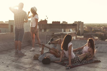Téléchargez les photos : Les jeunes se rafraîchissent et font la fête sur le toit d'un immeuble - en image libre de droit