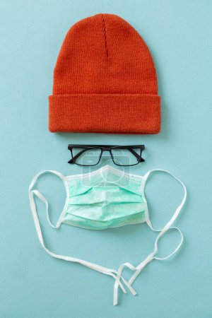 Photo for Surgical face protection mask glasses and a hat isolated on green color background. Medical face protection mask as part of protection gear against coronavirus infection - Royalty Free Image
