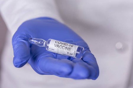Téléchargez les photos : Immunologue tenant un flacon de vaccin covide-19 ; médecin tenant un nouveau vaccin contre le corronavirus - en image libre de droit