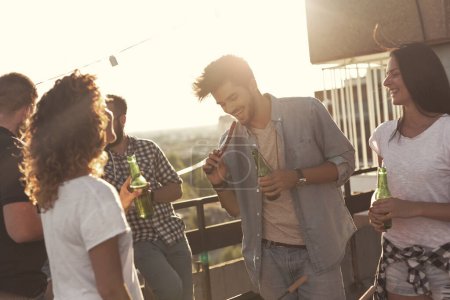 Téléchargez les photos : Groupe de jeunes amis s'amuser à la fête sur le toit, faire un barbecue et profiter des chaudes journées d'été - en image libre de droit