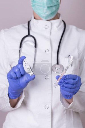 Téléchargez les photos : Immunologue tenant un flacon et une seringue de vaccin covid-19 ; médecin tenant un nouveau vaccin contre le corronavirus - en image libre de droit