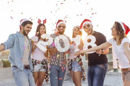 Téléchargez les photos : Groupe de jeunes amis célébrant le Nouvel An, dansant, chantant et s'amusant lors d'une fête sur le toit d'un bâtiment - en image libre de droit