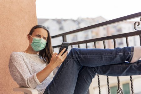 Photo for Woman wearing surgical mask outdoors as part of coronavirus protection and prevention protocols; woman in home isolation during covid-19 pandemic - Royalty Free Image