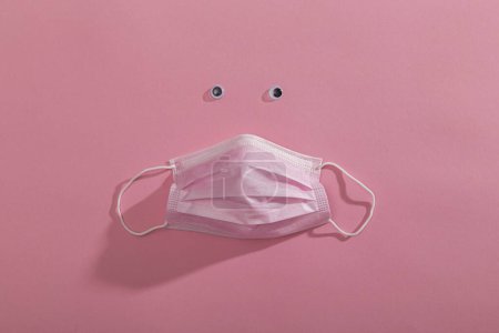 Photo for Top view of pink surgical face protection mask isolated on pink color background. Medical mask as part of protection equipment against covid-19 virus outbreak - Royalty Free Image