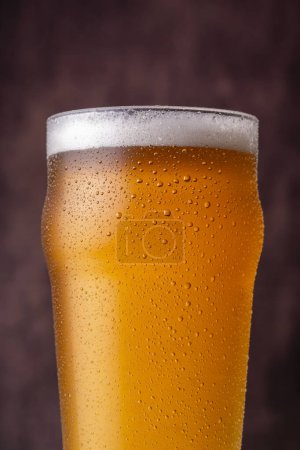 Foto de Primer plano del vaso de cerveza fría con gotas de rocío y agua condensada en la superficie del vaso - Imagen libre de derechos