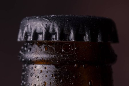 Foto de Detalle de botella de cerveza fría y húmeda con gotas de rocío y agua condensada en la superficie del vidrio - Imagen libre de derechos