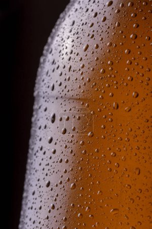 Téléchargez les photos : Macro image de bouteille de bière froide et humide avec de la rosée et des gouttelettes d'eau de condensat à la surface du verre - en image libre de droit
