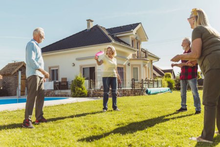 Photo for Group of active senior people having fun spending sunny summer day outdoors, playing catch and toss - Royalty Free Image