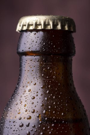 Téléchargez les photos : Détail de la bouteille de bière froide et humide avec un bouchon, de la rosée et des gouttelettes d'eau de condensat à la surface du verre - en image libre de droit