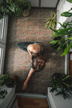 Téléchargez les photos : Vue du dessus de la belle jeune femme en vêtements de sport faisant de l'exercice à la maison le matin - en image libre de droit