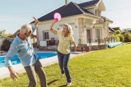 Photo for Senior couple having fun spending sunny summer day outdoors, playing catch and throw - Royalty Free Image