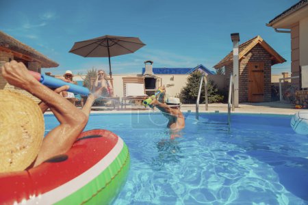 Photo for Group of elderly people having fun spending hot summer day at the swimming pool, sunbathing, floating on air mattress and splashing water on each other, cooling down and relaxing - Royalty Free Image