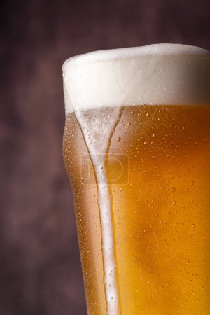 Téléchargez les photos : Détail de la pinte de bière froide pâle avec mousse fuyant sur le verre - en image libre de droit