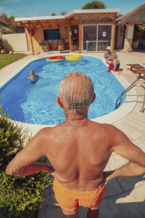 Photo for Group of elderly friends relaxing and sunbathing by the swimming pool on a hot sunny summer day while on a vacation - Royalty Free Image