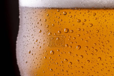 Téléchargez les photos : Gros plan du verre de bière froide avec de la rosée et des gouttelettes d'eau de condensat à la surface du verre - en image libre de droit