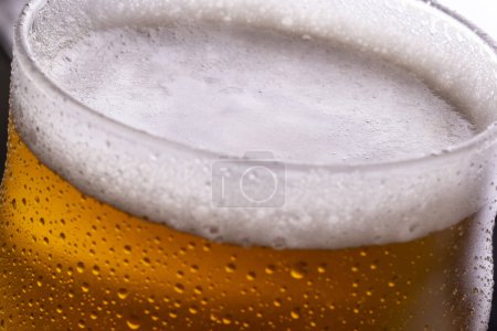 Foto de Primer plano del vaso de cerveza fría con gotas de rocío y agua condensada en la superficie del vaso - Imagen libre de derechos