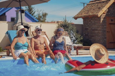 Photo for Group of elderly people having fun spending hot sunny summer day at the swimming pool, sunbathing and splashing water on each other, cooling down and relaxing while on a vacation - Royalty Free Image