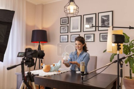 Photo for Female vlogger recording tutorial about breast pump use instructions as part of online prenatal classes course - Royalty Free Image