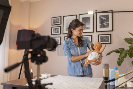 Photo for Midwife making video about double diapering and newborn baby proper hip positioning to prevent hip dysplasia as part of online birthing classes course - Royalty Free Image