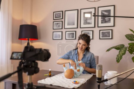 Photo for Female vlogger making video about newborn baby belly massage and stimulating the bowel movements to prevent baby colic as part of online prenatal classes course - Royalty Free Image