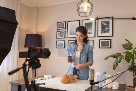 Photo for Health care specialist recording educational newborn baby care videos about umbilical cord care and disinfection as part of online prenatal classes - Royalty Free Image