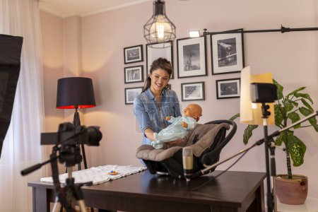 Téléchargez les photos : Vlogger femelle enregistrant une vidéo sur la manipulation et le positionnement du nouveau-né et l'utilisation d'un siège auto pour le transport en toute sécurité dans le cadre de cours prénatals en ligne - en image libre de droit