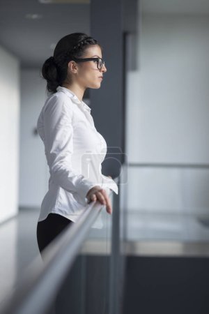 Foto de Mujer fuerte, segura, de negocios de pie en un pasillo del edificio de oficinas - Imagen libre de derechos