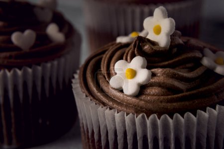 Téléchargez les photos : Plusieurs muffins au chocolat joliment décorés sur un fond en bois - en image libre de droit