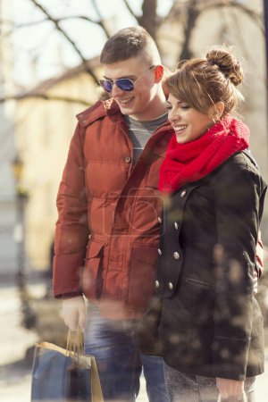 Photo for Beautiful young couple going shopping and carrying shopping bags. - Royalty Free Image