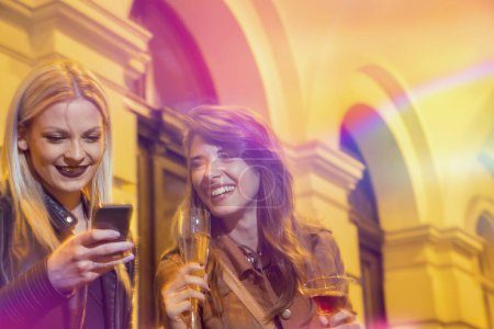 Photo for Two beautiful girls drinking and having fun on a girls' night out - Royalty Free Image