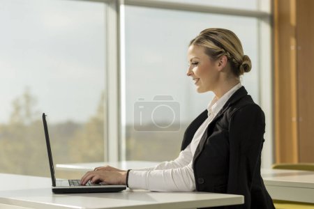 Téléchargez les photos : Jeune femme d'affaires assise à son bureau, buvant du café et planifiant un nouveau projet - en image libre de droit