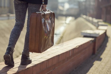Foto de Chica joven urbana, caminando por la calle y llevando maleta - Imagen libre de derechos