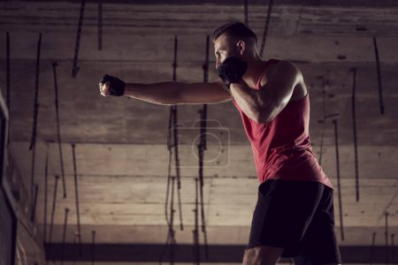 Téléchargez les photos : Jeune homme bâti athlétique travaillant dans un bâtiment abandonné, boxe - en image libre de droit