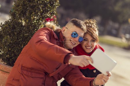 Téléchargez les photos : Beau jeune couple prenant un selfie dans une ville - en image libre de droit