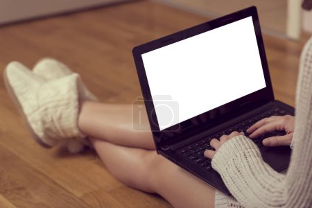 Foto de Detalle de una joven sosteniendo un ordenador portátil en su regazo y escribiendo, disfrutando de su tiempo libre - Imagen libre de derechos