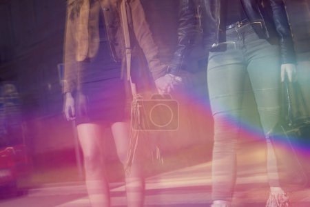 Photo for Two girls walking down the city streets, ready for a night out with friends - Royalty Free Image