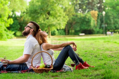 Téléchargez les photos : Couple assis sur une couverture de pique-nique, tous deux chers, profitant du calme et de la nature - en image libre de droit