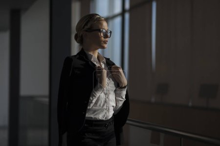 Téléchargez les photos : Femme d'affaires forte, confiante, debout dans un couloir d'immeuble de bureaux - en image libre de droit