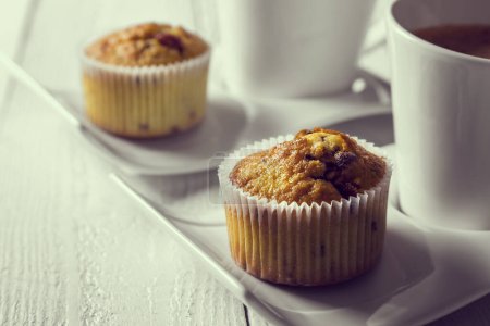 Téléchargez les photos : Deux tasses de café sur des assiettes à côté d'un chocolat croque muffins sur une table en bois - en image libre de droit