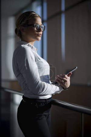 Strong, confident, business woman standing in an office building, holding tablet computer