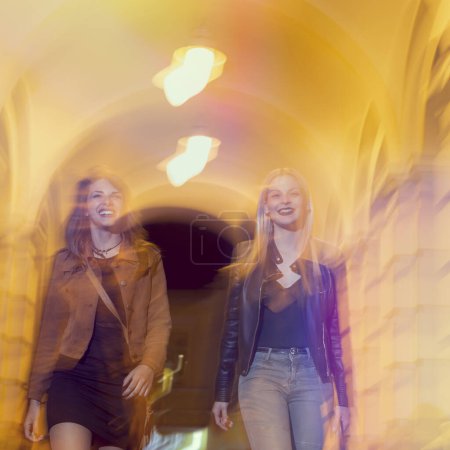 Foto de Dos chicas caminando por las calles de la ciudad, listas para una noche con amigos - Imagen libre de derechos