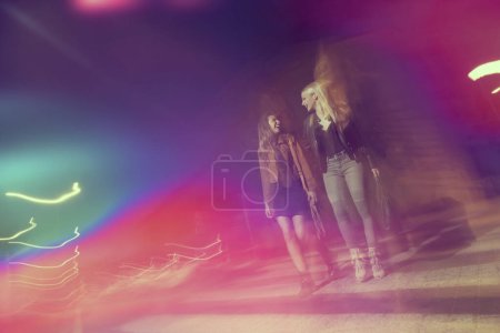 Photo for Two girls walking down the city streets, ready for a night out with friends - Royalty Free Image