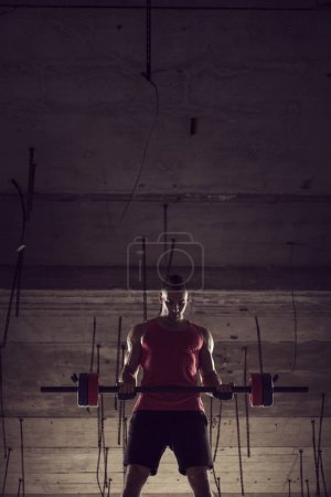 Photo for Muscular, athletic built, young athlete lifting weights in an abandoned ruin building - Royalty Free Image
