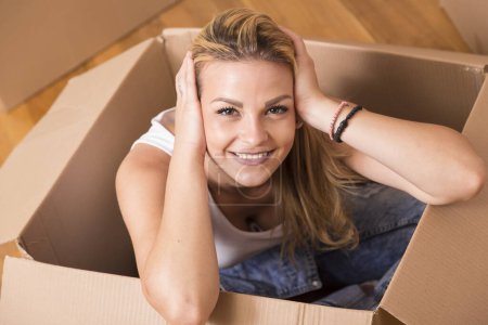 Photo for Woman sitting inside a cardboard box while packing - Royalty Free Image