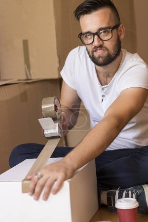Foto de Joven empacando cosas y grabando cajas, preparándose para mudarse del apartamento - Imagen libre de derechos